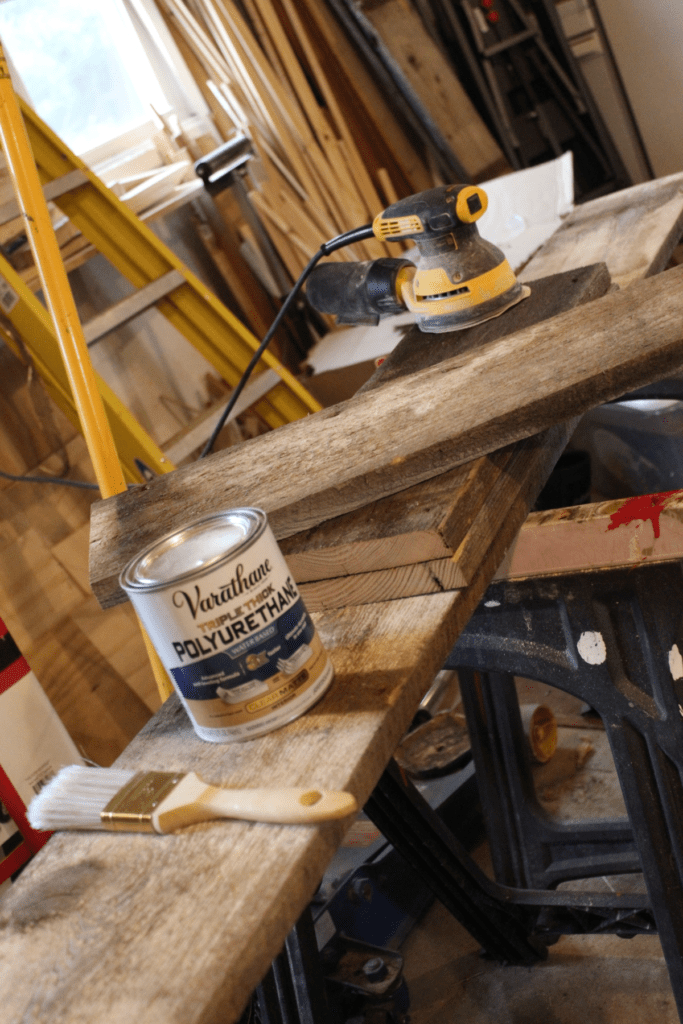 Cast of characters for cleaning and sealing the reclaimed barnwood.  orbital sander, polyurethane, wood, brush