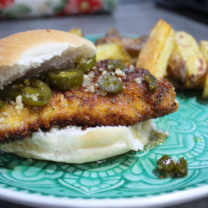 Fried Chicken sandwich with jalapeno honey sauce and potato wedges on the side