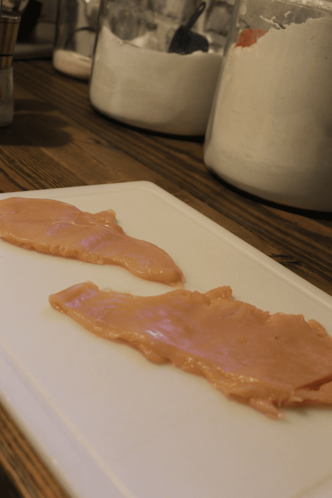 pounded out chicken on a cutting board