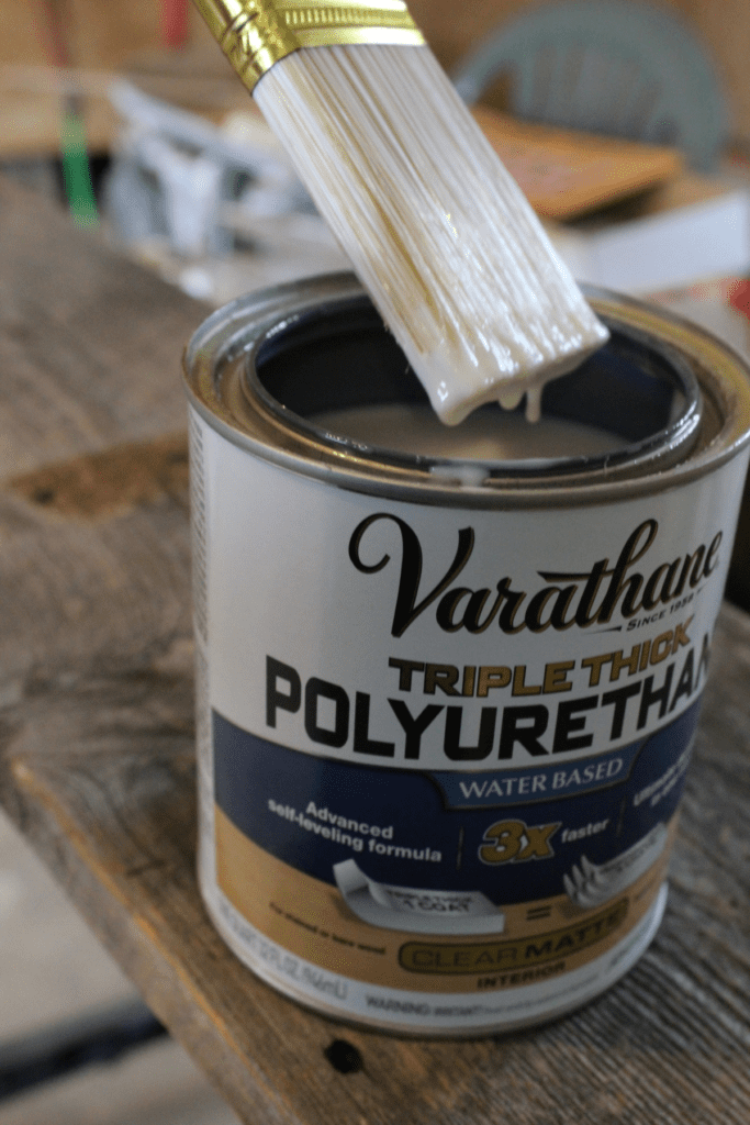 can of polyurethane with paint brush