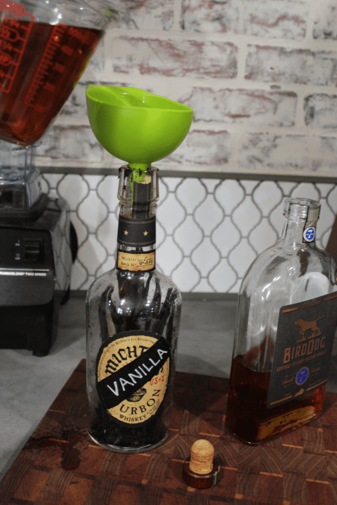 Funnel the bourbon into the vanilla bottle